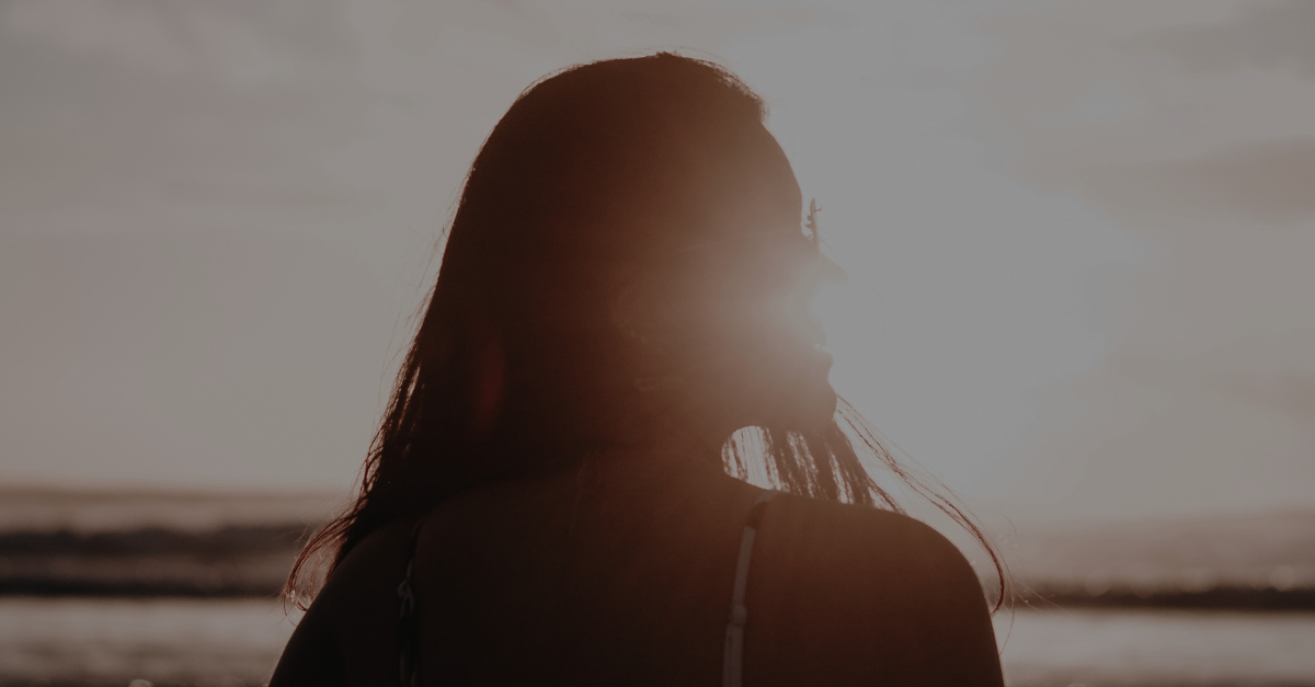 Woman standing in natural sunlight outdoors in spring to support circadian rhythm and build sun tolerance
